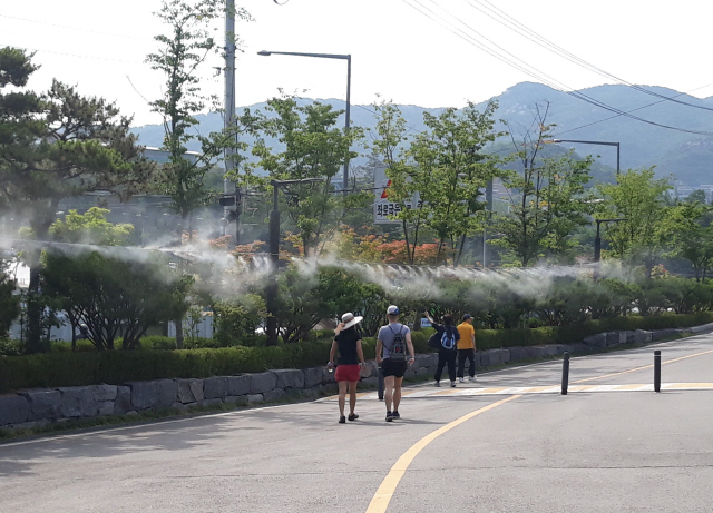 ‘쿨링포그’가 설치된 관악산 등산로를 주민들이 걷고 있다.    /사진제공=관악구