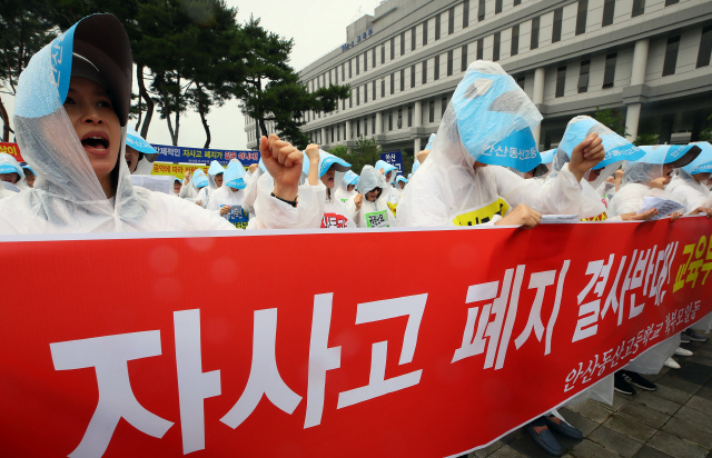 경기교육청으로부터 자사고 지정취소 결정을 통보받은 안산 동산고 학부모들이 11일 정부세종청사 앞에서 비옷을 입은 채 자사고 폐지 반대 구호를 외치고 있다.      /연합뉴스