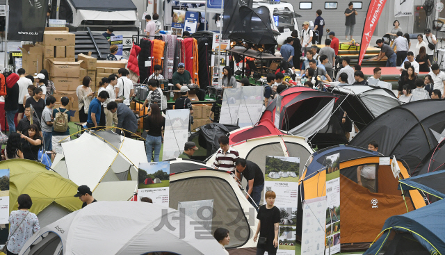 '2019 캠핑&피크닉페어'가 개막한 12일 경기도 수원시 영통구 수원컨벤션센터에서 관람객들이 다양한 캠핑용품과 레저차량 등을 살펴보고 있다. 이번 행사는 오는 14일까지 열린다./수원=오승현기자 2019.7.12