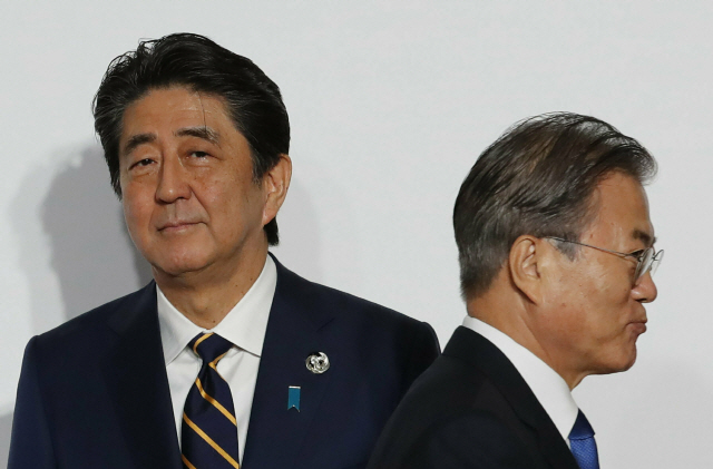 문재인 대통령과 아베 신조 일본 총리가 지난 달 28일 일본 오사카에서 열린 G20 정상회의에서 기념 촬영 후 스쳐지나가고 있다./AP연합뉴스