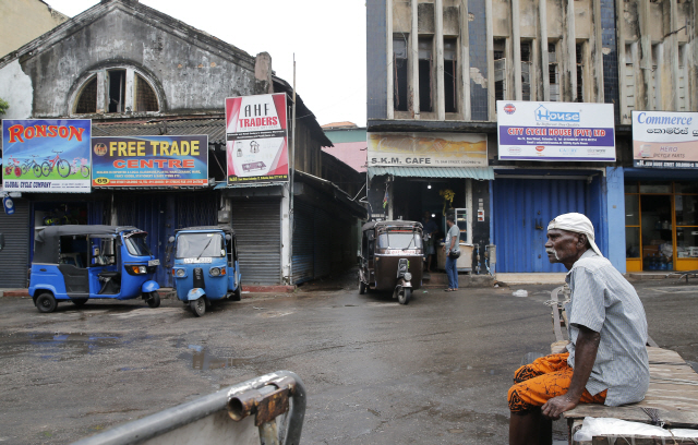 스리랑카 일용직 근로자가 콜롬보의 한 시장에서 일하기 위해 앉아있다. /AP연합뉴스