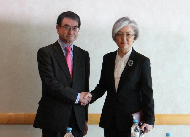강경화(오른쪽) 외교부 장관과 고노 다로 일본 외무상이 지난 2월 독일에서 한일 외교장관 회담을 갖고 악수하고 있다./뮌헨=연합뉴스