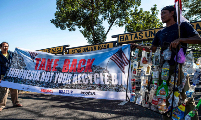 지난 12일(현지시간) 인도네시아 동부 자바 수라바야 주재 미국 총영사관 앞에서 집회 참여자들이 미국이 인도네시아로 쓰레기를 수출하는 것에 항의하고 있다. /AFP=연합뉴스