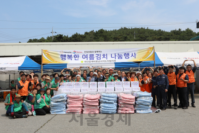 한화토탈 임직원과 충남 서산 대산읍 주민들이 함께 여름김치 나눔 행사를 개최한 뒤 자리를 함께 하고 있다. 사진제공=한화토탈