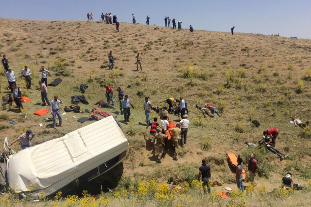 18일(현지시간) 터키 동부 반주(州)의 이란 국경 인근 고속도로에서 난민 수십 명이 탄 미니버스가 언덕 아래로 떨어지는 사고가 발생한 직후 구조대원들과 군인들이 출동해 구조작업을 벌이고 있다. /이스탄불=AFP연합뉴스