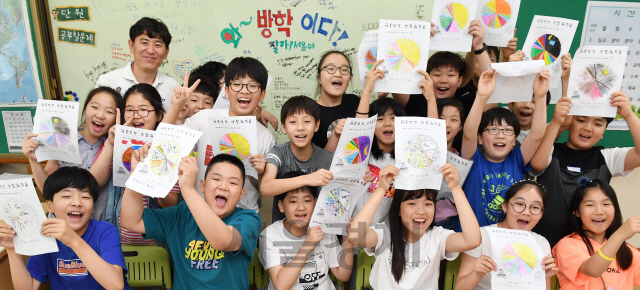 19일 서울 구로구 고원초등학교에서 방학식을 마친 어린이들이 직접 만든 생활계획표를 들어 보이며 
