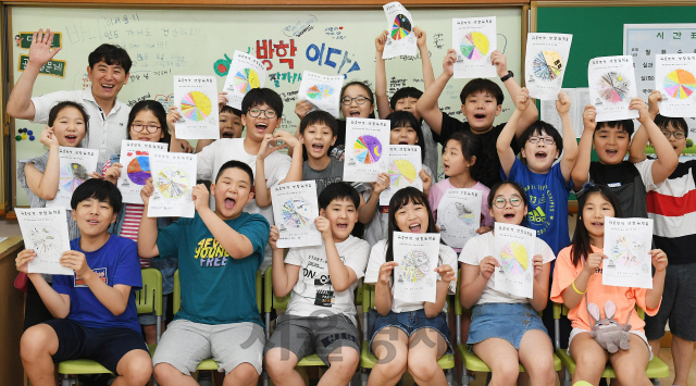 19일 서울 구로구 고원초등학교에서 방학식을 마친 어린이들이 직접 만든 생활계획표를 들어 보이며 