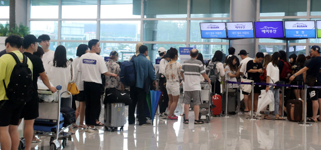 제5호 태풍 ‘다나스’의 영향으로 20일 오전 제주공항 이용객들이 항공권을 교환하려고 길게 줄을 서 있다./제주=연합뉴스