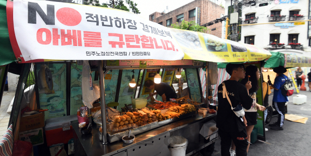 21일 서울 마포구 홍대입구역 인근 노점상에 'NO 적반하장 경제보복 아베를 규탄합니다'는 현수막이 걸려있다. 서부지역노점상연합회 소속의 한 노점 상인은 