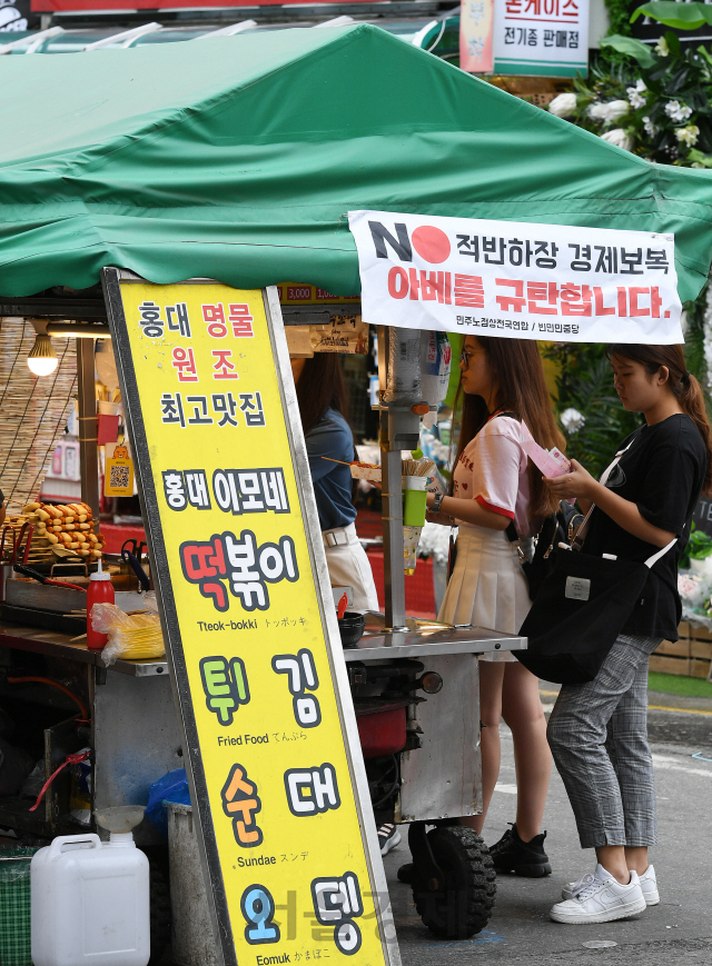 21일 서울 마포구 홍대입구역 인근 노점상에 'NO 적반하장 경제보복 아베를 규탄합니다'는 현수막이 걸려있다. 서부지역노점상연합회 소속의 한 노점 상인은 