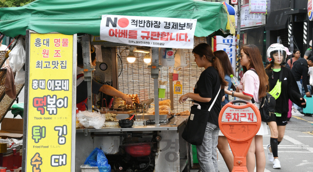 21일 서울 마포구 홍대입구역 인근 노점상에 'NO 적반하장 경제보복 아베를 규탄합니다'는 현수막이 걸려있다. 서부지역노점상연합회 소속의 한 노점 상인은 