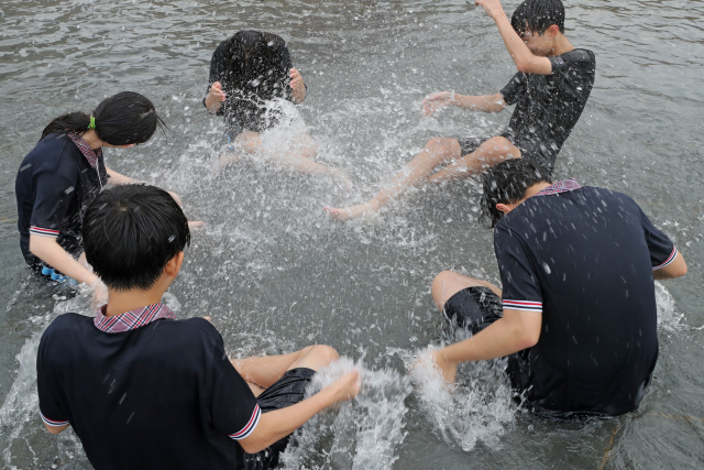 폭염특보가 발효됐던 지날 19일 서울 영등포구 여의도한강공원 물빛광장에서 학생들이 물놀이를 즐기고 있다. /연합뉴스