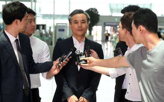 WTO 일반이사회 수석대표를 맡은 김승호(가운데) 산업부 신통상질서전략실장이 22일 인천국제공항에서 기자들의 질문에 답하고 있다. /이호재기자