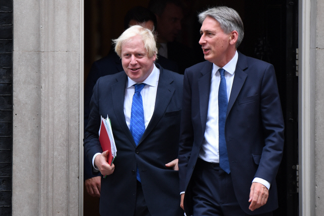 보리스 존슨(왼쪽) 전 영국 외무장관과 필립 해먼드 재무장관이 지난 2017년 9월21일(현지시간) 런던에서 열린 내각회의를 마친 뒤 걸어나오고 있다. /런던=AFP연합뉴스