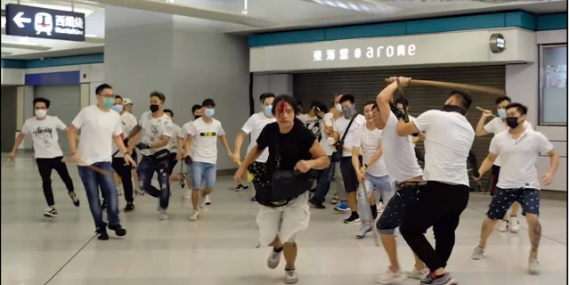 21일(현지시간) 홍콩 위안랑전철역에서 흰 상의에 마스크를 착용한 남성들이 송환법 반대시위에 참여한 시민들에게 쇠막대기와 각목을 휘두르고 있다.      /유튜브 캡처