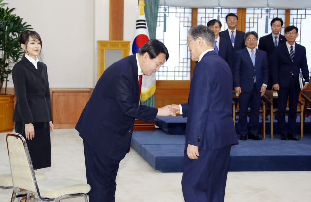 문재인 대통령이 25일 오전 청와대에서 윤석열 신임 검찰총장에게 임명장을 수여하기에 앞서 윤 총장의 부인 김건희(왼쪽)씨가 지켜보는 가운데 윤 총장과 악수하고 있다. 문 대통령은 “권력에 휘둘리지 않고 눈치도 보지 않고 사람에게 충성하지 않는 자세가 청와대든 여당이든 살아 있는 권력에 대해서도 같아야 한다”고 윤 총장에게 당부했다. /연합뉴스