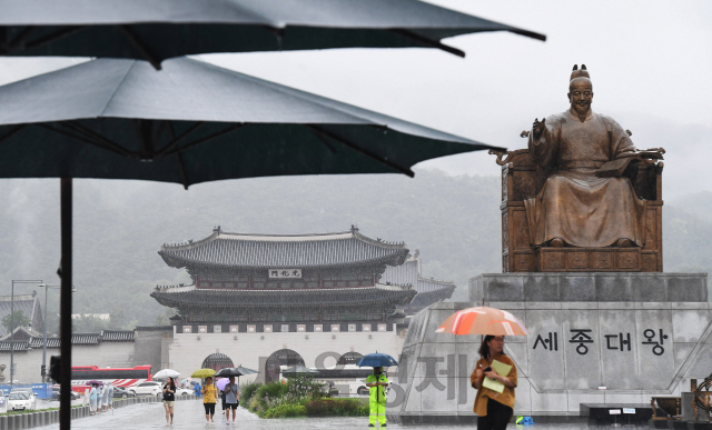 수도권 전지역에 호우경보가 내려지는 등 많은 양의 막바지 장맛비가 내린 26일 오전 서울 광화문광장에서 우산을 쓴 시민들이 발걸음을 재촉하고 있다./오승현기자 2019.7.26