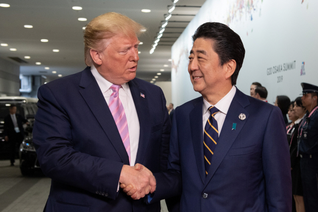 도널드 트럼프(왼쪽) 미국 대통령과 아베 신조 일본 총리가 지난달 28일(현지시간) 일본 오사카에서 열린 G20 정상회의에서 악수하며 인사를 나누고 있다. /오사카=블룸버그
