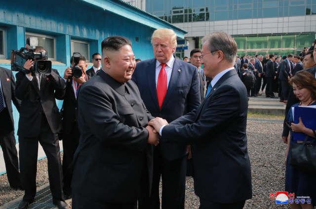 문재인 대통령과 김정은 북한 국무위원장이 6월 30일 오후 판문점에서 두손을 맞잡고 대화하고 있다. 가운데는 도널드 트럼프 미국 대통령./판문점 조선중앙통신=연합뉴스