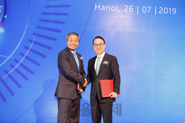 홍원표(오른쪽) 삼성SDS 대표와 응우엔 쭝 찡 CMC 대표가 지난 26일 베트남 하노이에서 전략적 투자 계약 체결을 한 뒤 악수하고 있다./사진제공=삼성SDS