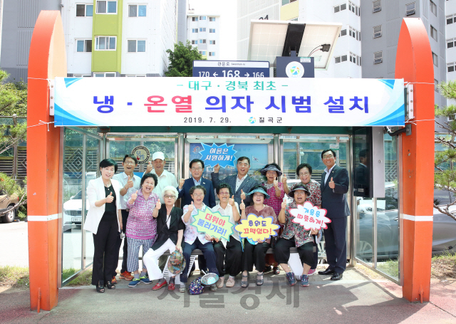 칠곡군 마을 주민들이 버스 승강장에 설치된 냉온열 의자에 앉아 기념 촬영을 하고 있다./사진제공=칠곡군