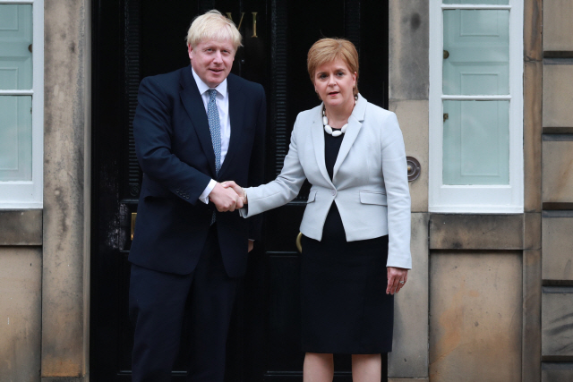 보리스 존슨(왼쪽) 영국 총리가 29일(현지시간) 스코틀랜드 에든버러를 찾아 니콜라 스터전 스코틀랜드 자치정부 제1장관과 악수하고 있다.  /에든버러=AP연합뉴스
