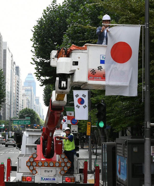 2일 오후 서울 강남구 테헤란로에서 구청 관계자들이 일본의 화이트리스트 한국 제외조치에 대한 항의 표시로 거리에 게양된 만국기 중 일장기를 하기하고 있다. 강남구는 테헤란로와 영동대로, 압구정로데오거리에 게양된 일장기 14기를 모두 하기하고 일본의 수출규제조치 철회 시까지 자리를 비워둘 방침이다./오승현기자 2019.8.2