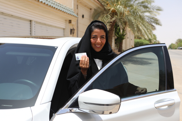 한 사우디아라비아 출신 여성이 지난해 6월 25일(현지시간) 수도 리야드에서 공식 운전면허증을 들어 보이며 환하게 웃고 있다. /리야드=블룸버그