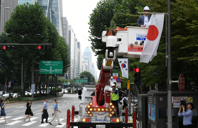 2일 오후 서울 강남구 테헤란로에서 구청 관계자들이 일본의 화이트리스트 한국 제외조치에 대한 항의 표시로 거리에 게양된 만국기 중 일장기를 하기하고 있다. 강남구는 테헤란로와 영동대로, 압구정로데오거리에 게양된 일장기 14기를 모두 하기하고 일본의 수출규제조치 철회 시까지 자리를 비워둘 방침이다./오승현기자 2019.8.2