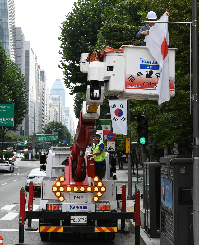 2일 오후 서울 강남구 테헤란로에서 구청 관계자들이 일본의 화이트리스트 한국 제외조치에 대한 항의 표시로 거리에 게양된 만국기 중 일장기를 하기하고 있다. 강남구는 테헤란로와 영동대로, 압구정로데오거리에 게양된 일장기 14기를 모두 하기하고 일본의 수출규제조치 철회 시까지 자리를 비워둘 방침이다./오승현기자 2019.8.2