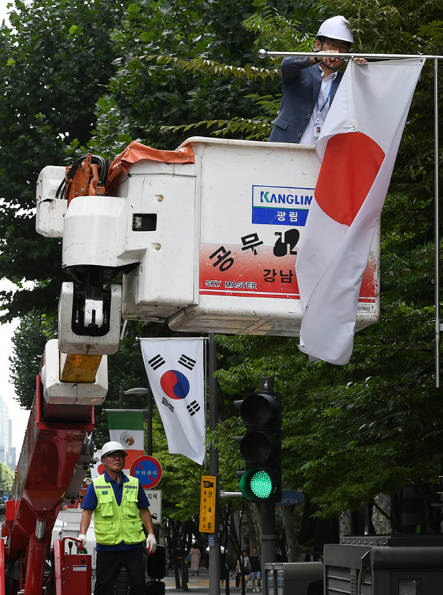 “日 철회 전까지 일장기는 없다”  서울 강남구청 직원이 2일 오후 테헤란로에 게양된 만국기 가운데 일장기를 내리고 있다. 강남구는 일본의 수출규제 조치가 철회될 때까지 이곳에 게양된 일장기 14기를 모두 내리고 자리를 비워둘 방침이다.     /오승현기자