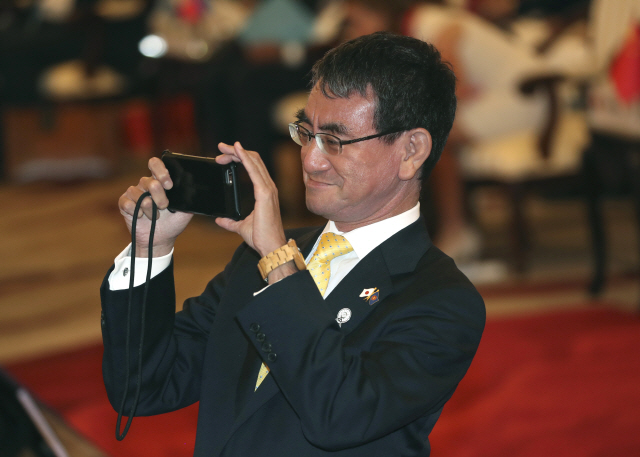 고노 다로 일본 외무상이 2일(현지시간) 방콕에서 열린 아세안지역안보포럼(ARF)에서 카메라를 들고 사진을 찍고 있다./방콕=AP연합뉴스