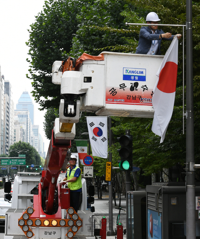 2일 오후 서울 강남구 테헤란로에서 구청 관계자들이 일본의 화이트리스트 한국 제외조치에 대한 항의 표시로 거리에 게양된 만국기 중 일장기를 하기하고 있다. 강남구는 테헤란로와 영동대로, 압구정로데오거리에 게양된 일장기 14기를 모두 하기하고 일본의 수출규제조치 철회 시까지 자리를 비워둘 방침이다./오승현기자 2019.8.2