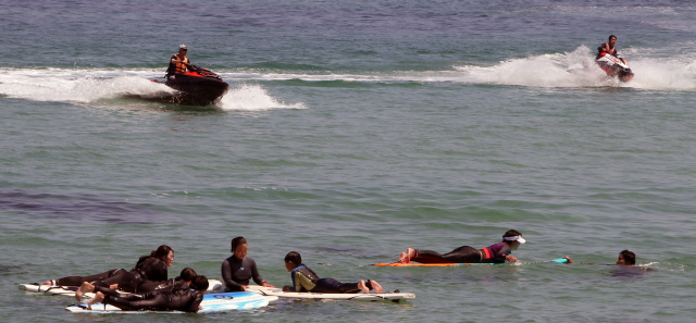 지난 2일 오후 강원 강릉시 사천진해변에서 피서객들이 서핑을 배우며 무더위를 식히고 있다. /연합뉴스