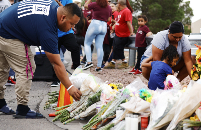 4일(현지시간) 전날 총기 난사 사건이 벌어진 미국 텍사스주 엘패소의 월마트 앞에 사람들이 희생자들을 추모하는 의미로 꽃을 놓고 있다. /엘패소=AFP연합뉴스