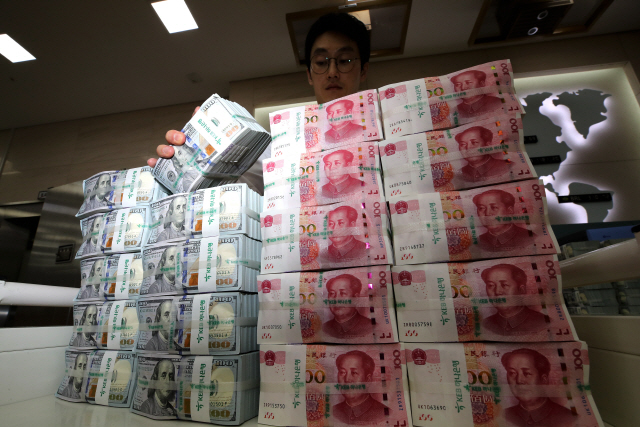 서울 중구 KEB하나은행 위변조대응센터에서 관계자가 미국 달러와 중국 위안화를 정리하는 모습. /연합뉴스