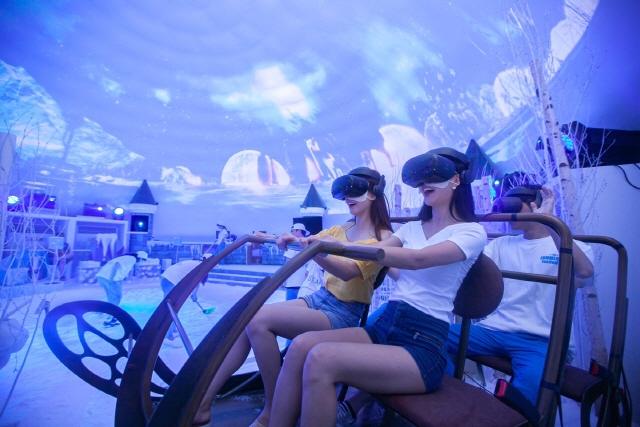 SK텔레콤 모델들이 ‘5GX 이글루 체험존’ 내 VR 눈썰매를 즐기고 있다./사진제공=SK텔레콤