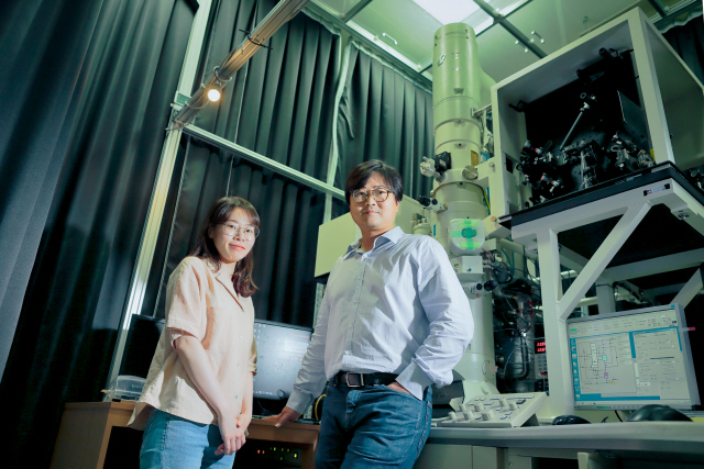 UNIST의 권오훈(오른쪽) 교수와 김예진 연구원이 자신들이 개발한 초고속 투과전자현미경 앞에 서서 해당 장비를 소개하고 있다. /사진제공=UNIST