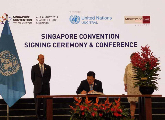 김오수 법무부 차관(가운데)이 7일 싱가포르에서 열린 싱가포르 조정협약 행사에 참석하여 협약에 서명하고 있다./사진제공=법무부