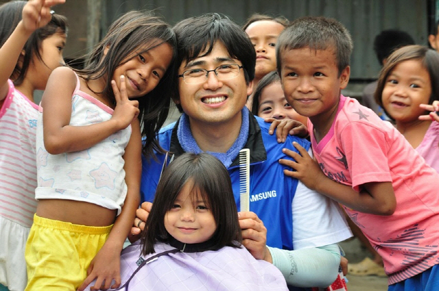김진묵씨가 지난 2012년 삼성전자 해외봉사 활동으로 필리핀을 방문해 아이들의 머리를 다듬어주고 있다. /삼성전자 뉴스룸