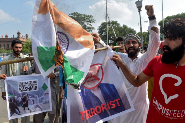 인도의 잠무카슈미르 자치권 박탈에 반발한 이슬람교도 학생들이 7일(현지시간) 파키스탄 라호르에서 나렌드라 모디 인도 총리의 사진과 인도 국기를 태우고 있다. /라호르=AFP연합뉴스