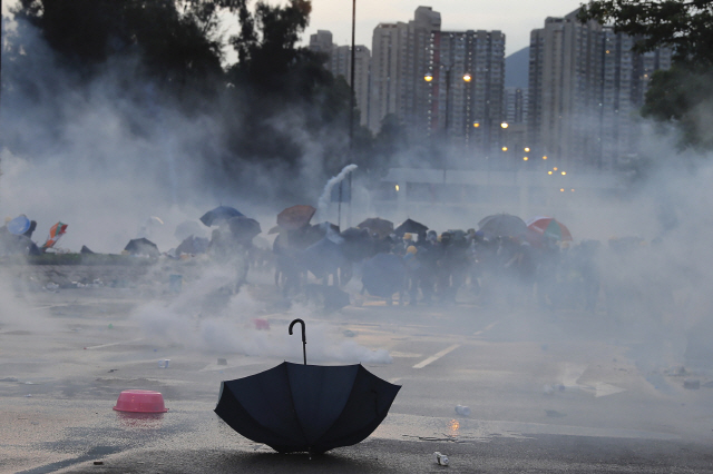 지난 5일 홍콩에서 ‘범죄인 인도 법안’(송환법) 반대 총파업을 지지하며 민주개혁을 촉구하는 시위대가 경찰의 최루탄 세례에 밀려나는 현장에 우산이 나딩굴고 있다. /연합뉴스