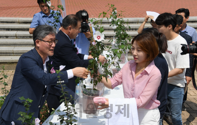 김재현(사진 왼쪽 첫번째) 산림청장 등 참석자들이 행사장을 찾은 관람객들에게 무궁화 묘목을  나눠주고 있다. 사진제공=산림청