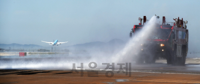 전국 대부분 지역에 폭염경보가 발효된 9일 인천국제공항 제1여객터미널 활주로에서 인천공항공사 관계자들이 공항소방대 소방차 및 살수차를 동원해 항공기의 안전 운항을 위한 살수작업을 벌이고 있다. 활주로 살수작업은 활주로 콘크리트 및 아스팔트 포장구간의 온도를 저하시켜 팽창을 억제하는 효과가 있다./영종도=오승현기자 2019.8.9