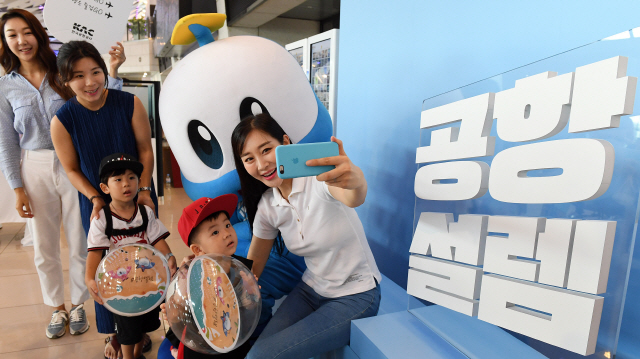 9일 서울시 강서구 김포공항 국내선 출발장에서 공항 이용객들이 한국공항공사에서 마련한 ‘#공항설렘 포토존’ 앞에서 사진을 찍고 있다. 공항공사는 여름철 국내 여행을 장려하기 위해 포토존, 사진 즉석인화 등 다양한 이벤트를 진행하고 있다.  /오승현기자