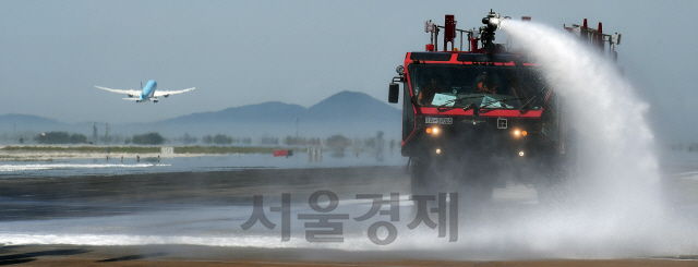 전국 대부분 지역에 폭염경보가 발효된 9일 인천국제공항 제1여객터미널 활주로에서 인천공항공사 관계자들이 공항소방대 소방차 및 살수차를 동원해 항공기의 안전 운항을 위한 살수작업을 벌이고 있다. 활주로 살수작업은 활주로 콘크리트 및 아스팔트 포장구간의 온도를 저하시켜 팽창을 억제하는 효과가 있다./영종도=오승현기자 2019.8.9