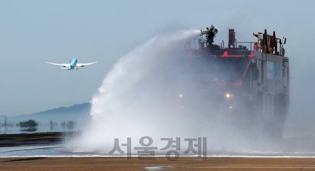 전국 대부분 지역에 폭염경보가 발효된 9일 인천국제공항 제1여객터미널 활주로에서 인천공항공사 관계자들이 공항소방대 소방차 및 살수차를 동원해 항공기의 안전 운항을 위한 살수작업을 벌이고 있다. 활주로 살수작업은 활주로 콘크리트 및 아스팔트 포장구간의 온도를 저하시켜 팽창을 억제하는 효과가 있다./영종도=오승현기자 2019.8.9