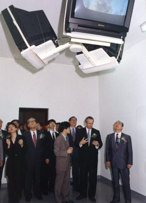 1993년 7월 과천 국립현대미술관에서 열린 ‘휘트니 비엔날레 서울’ 개막식에서 당시 학예연구사였던 최태만(오른쪽에서 세 번째) 국민대 교수, 객원학예사였던 김선정(맨 왼쪽) 광주비엔날레 대표이사가 매튜 바니의 비디오 설치작품 ‘그림-억제7’을 올려다보며 설명하고 있다. /사진제공=국립현대미술관 미술연구센터