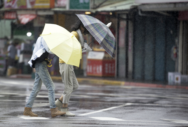 9일(현지시간) 대만 수도 타이베이에서 시민들이 제9호 태풍 ‘레끼마’가 몰고온 강풍에 맞서 길을 지나고 있다. /타이베이= AP연합뉴스