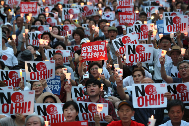 지난 10일 오후 서울 종로구 옛 주한 일본대사관 앞에서 열린 ‘아베규탄 4차 촛불문화제’에서 참가자들이 촛불과 손 피켓을 들고 있다. /연합뉴스